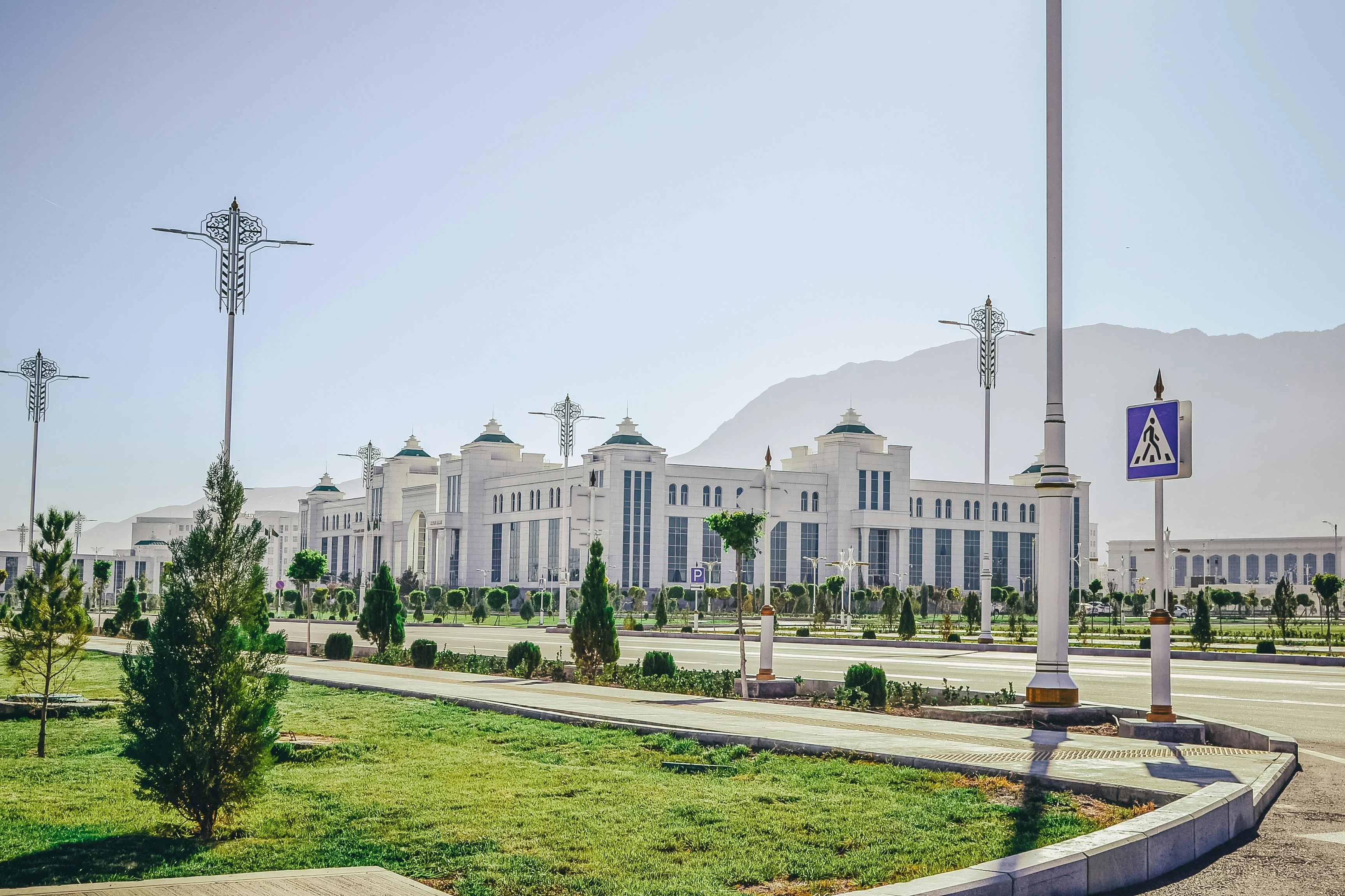 White marble government complex along a wide tree-lined avenue with the Kopet Dag mountains, Ashgabat