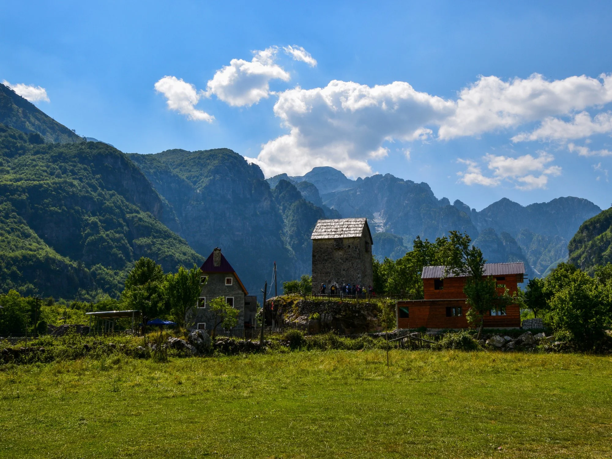 Theth's traditional lock-in stone tower framed by jagged Albanian Alps peaks, Albania