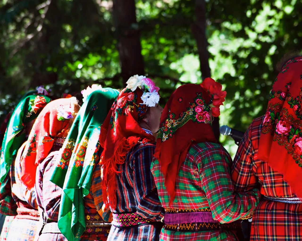 Women in traditional Bulgarian folk costumes with colorful embroidered headscarves at festival