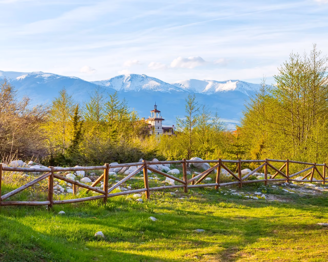 Wooden fence and spring landscape near Bansko with Pirin mountains in Bulgaria.