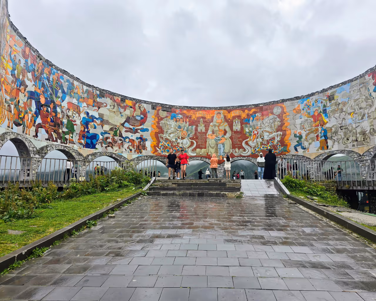 Close-up of the Gudauri viewpoint monument in Georgia, decorated with colorful murals depicting historical scenes.