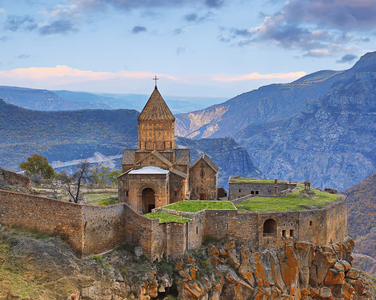 Ancient Tatev Monastery perched on a cliff in Armenia, with dramatic canyon views and historic stone walls.
