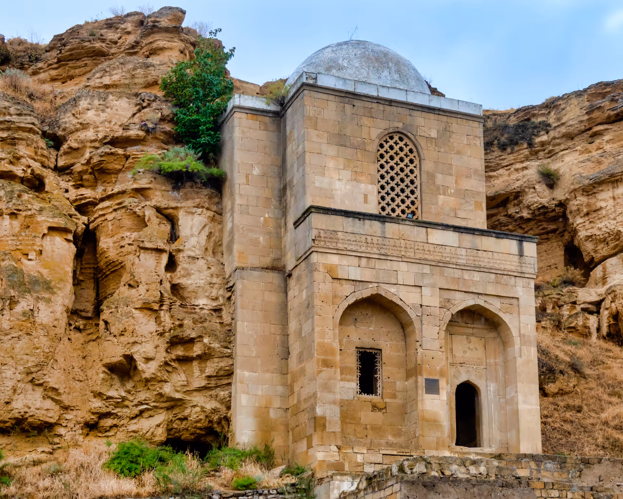 Diri Baba Mausoleum in Azerbaijan, an ancient stone tomb built in a rocky hillside with intricate Islamic architecture.