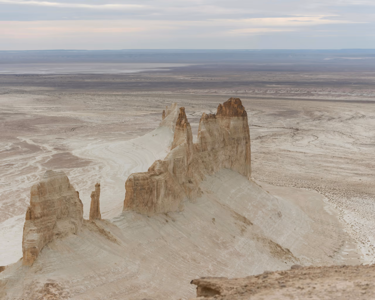 Dramatic white rock formations tower above the Mangystau desert, showcasing Kazakhstan’s raw natural beauty.
