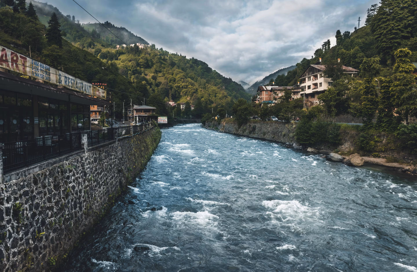 Fast-flowing mountain river through a forested Black Sea valley in north-east Turkey, with riverside houses
