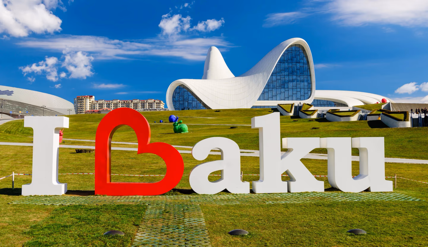 I Love Baku – large “I Love Baku” sign on green grass in front of the futuristic Heydar Aliyev Center in Azerbaijan.
