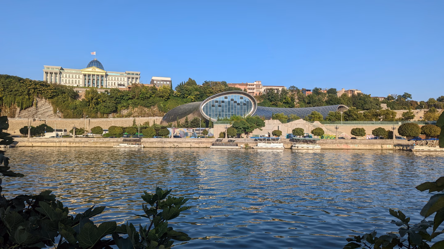 Tbilisi Rike Park – view across the Kura River to Rike Park’s tubular concert hall and the presidential palace on the hill in Tbilisi, Georgia.