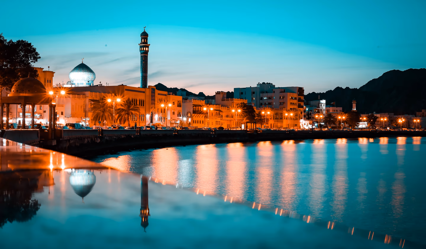 Night lights reflecting on Mutrah waterfront during a scenic Oman tour.