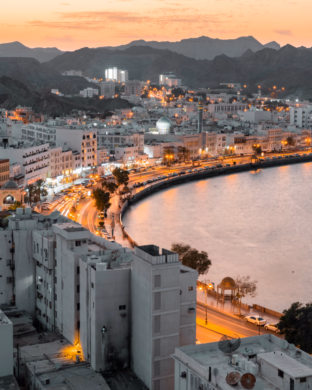 Sunset view of Mutrah Corniche skyline and waterfront on an Oman tour.