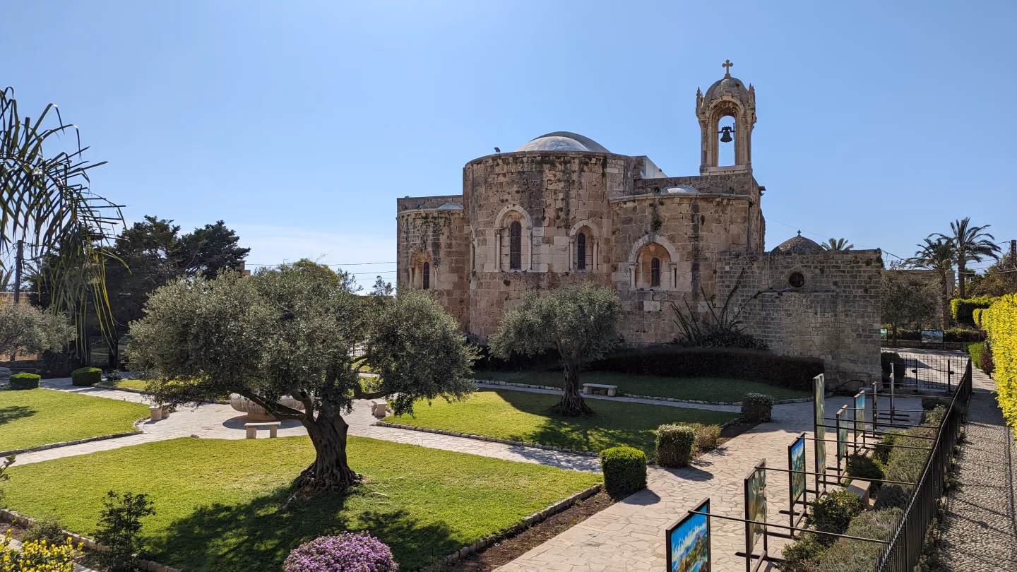 Saint John-Marc Cathedral in Byblos with manicured gardens and stone paths.