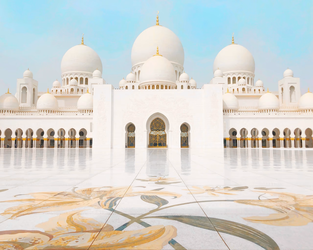 White domes and floral courtyard of Sheikh Zayed Grand Mosque