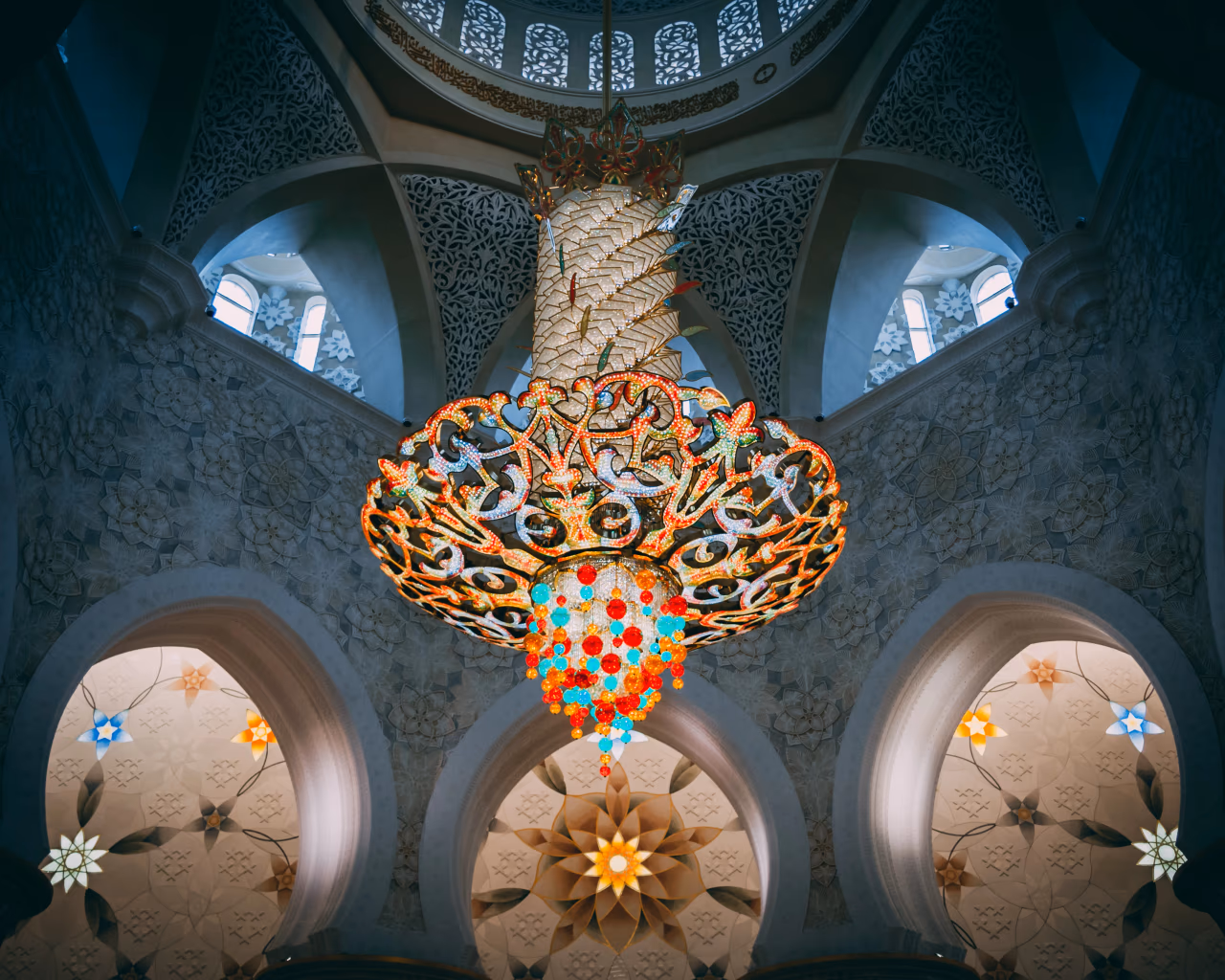 Colorful chandelier under patterned dome at Grand Mosque