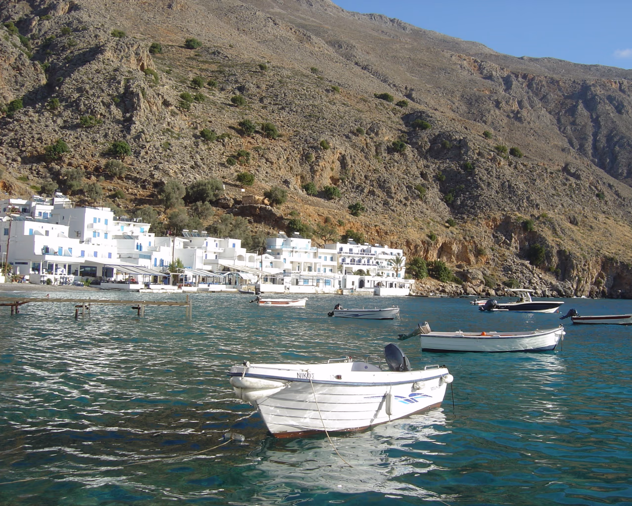 Sweeping scenic view of Crete's rugged coastline with hiking trails overlooking the turquoise Mediterranean Sea