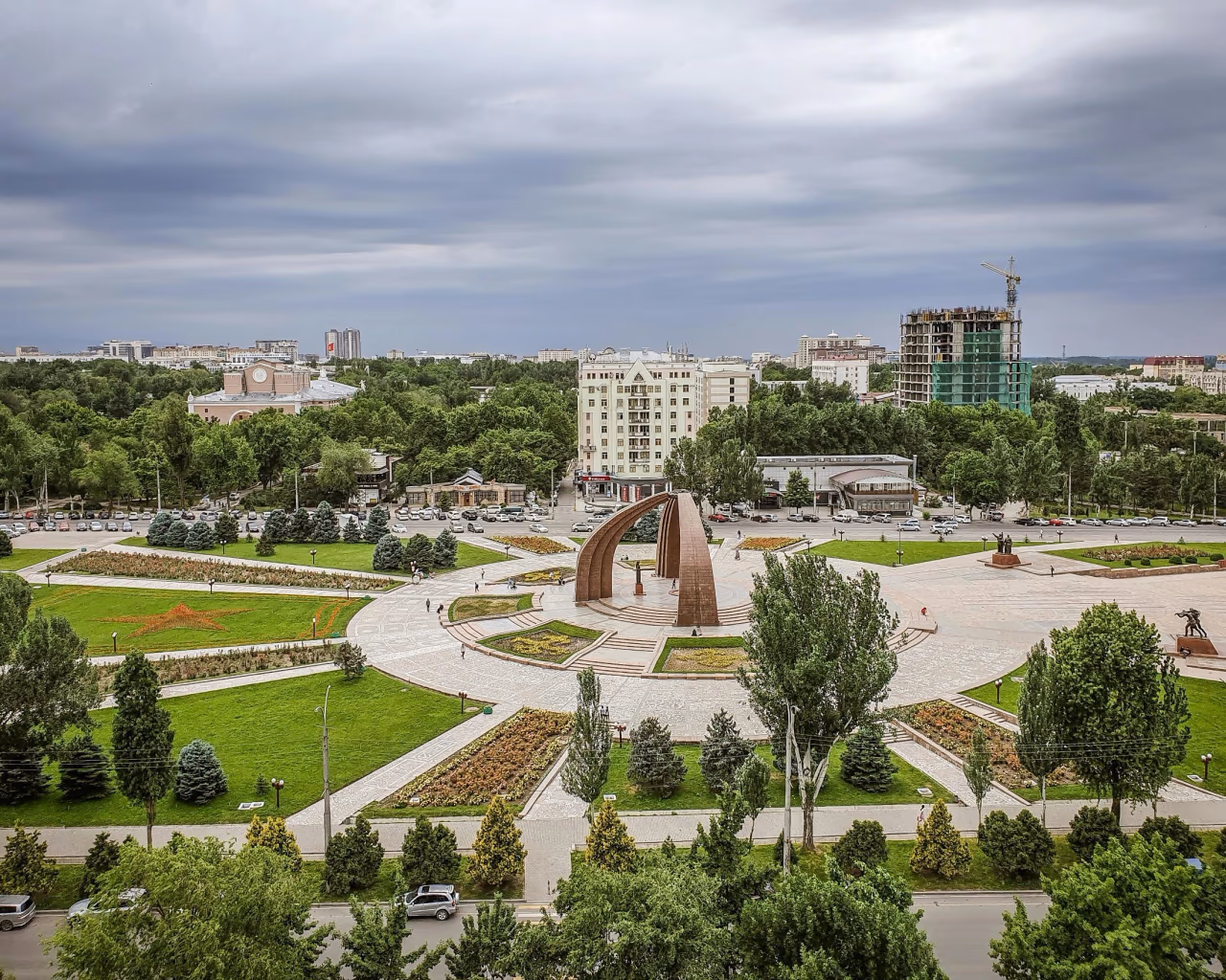 Bishkek city center view with green parks, buildings, and cloudy skies in Kyrgyzstan.
