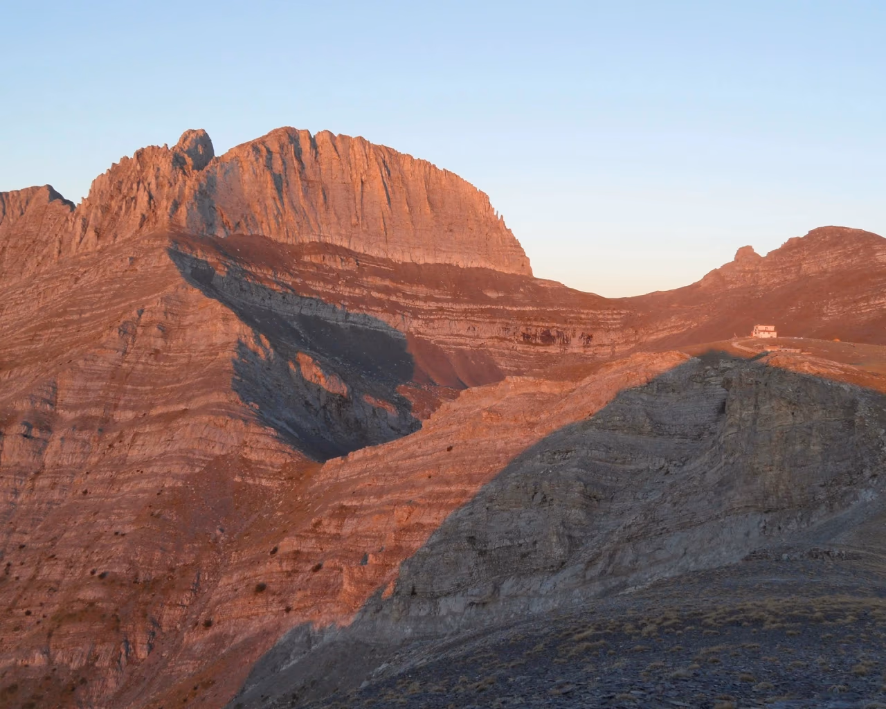Alpenglow at sunset on the peaks of Mount Olympus, Greece, highlighting the dramatic ridges and hiking trails.