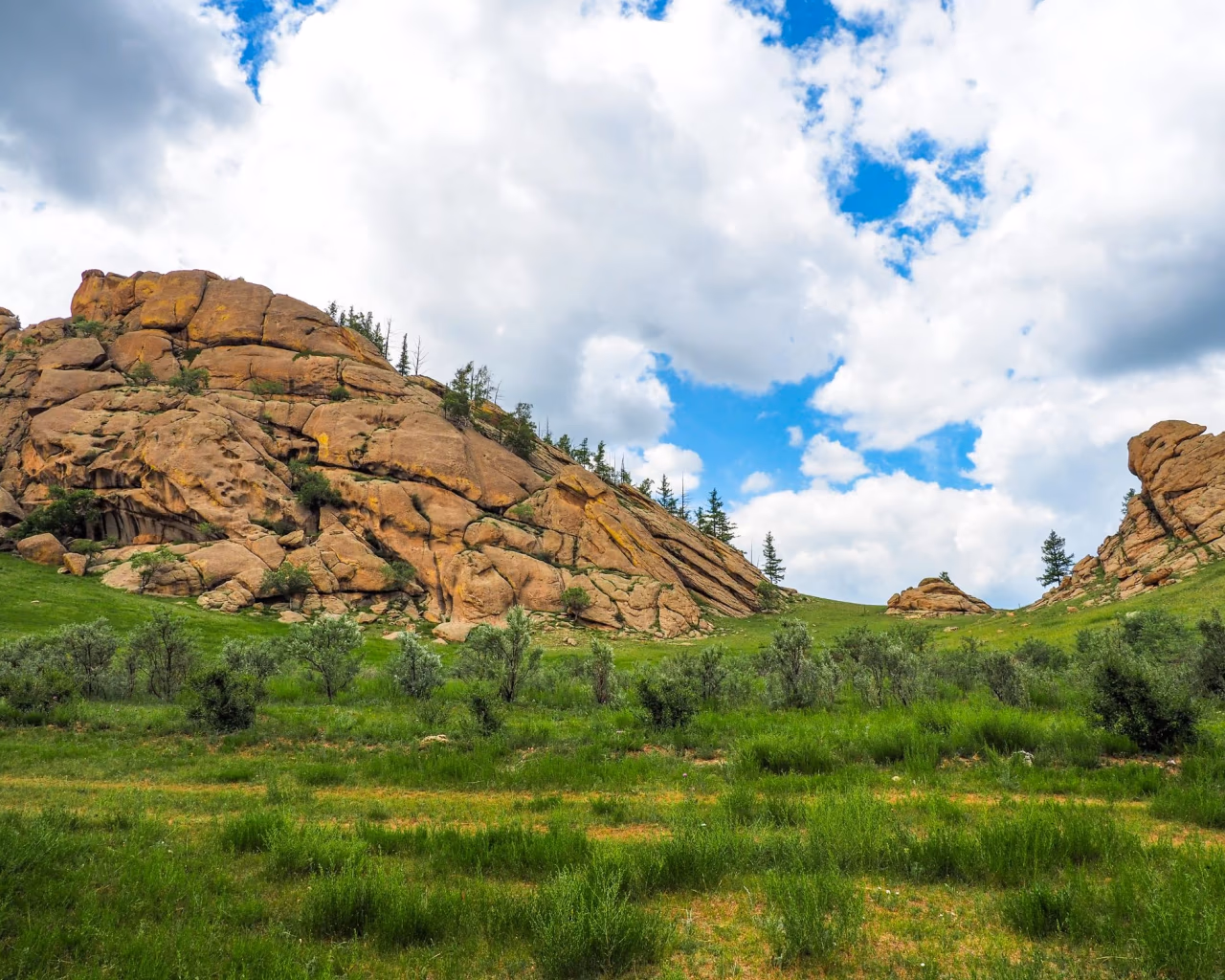 Lush green valley with rock formations in Terelj National Park, a top destination for Mongolia nature travel.