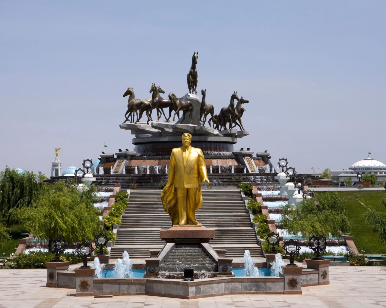 10 Years of Independence Monument in Ashgabat, Turkmenistan, with golden statue and fountains.