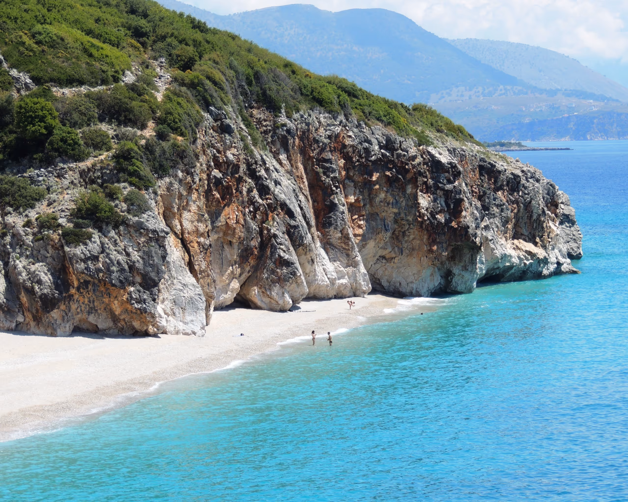 Hidden beach with turquoise waters and dramatic cliffs, a perfect secluded getaway on the Albanian coast.