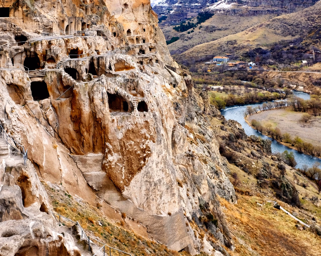 Vardzia Cave Monastery, Georgia (River View) - Panoramic view of Vardzia's ancient caves overlooking a winding river valley.