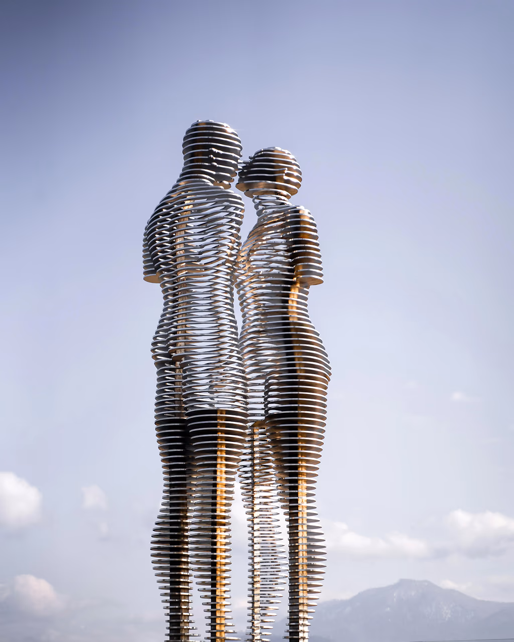 The "Ali and Nino" moving statue in Batumi, Georgia, depicting two lovers made of metal slats against a mountain backdrop.