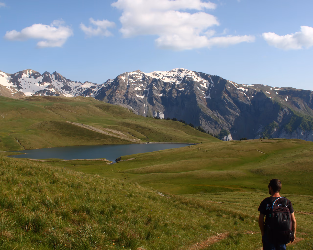 Scenic view of hikers trekking along the High Scardus Trail with rolling green hills and rugged mountain peaks in the Balkans.