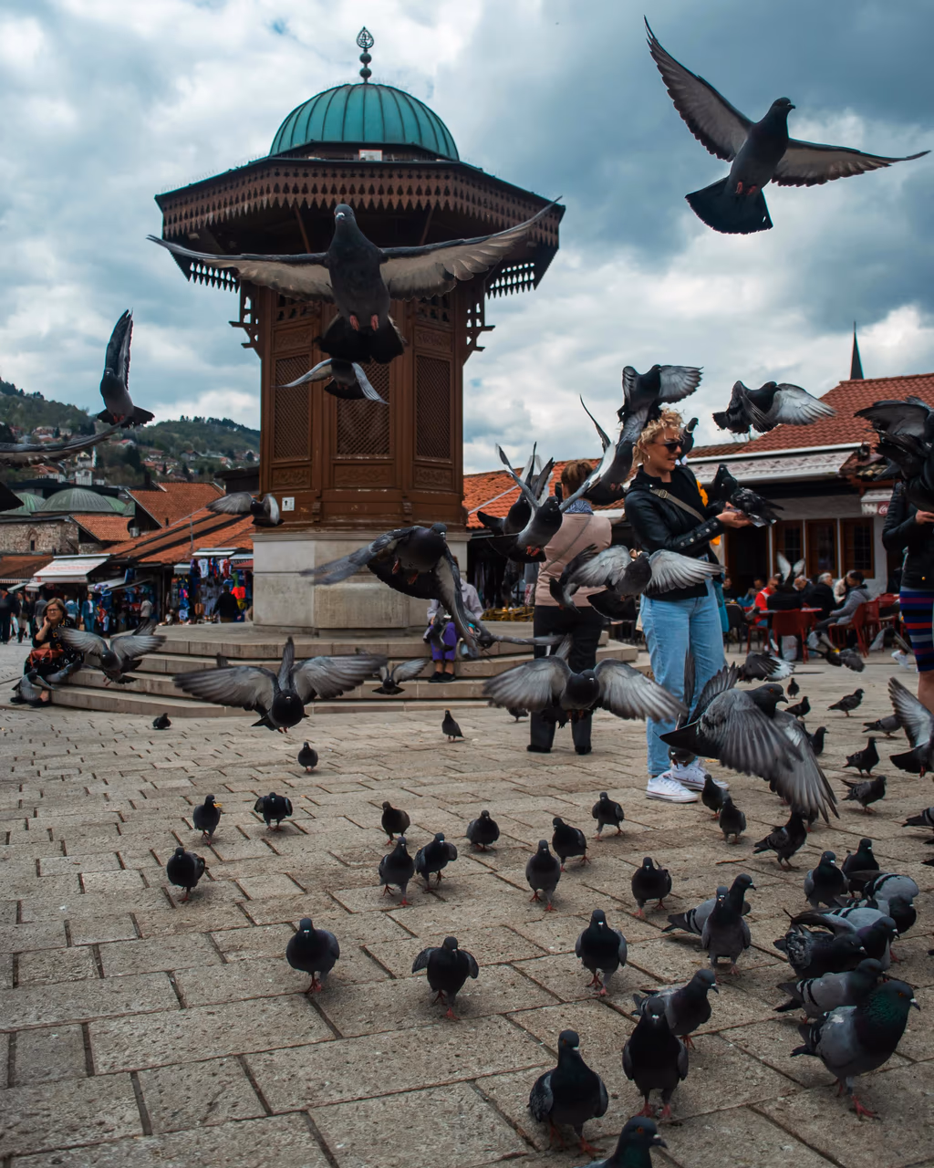 Panoramic view of Sarajevo’s red-roofed houses and minarets nestled among green hills