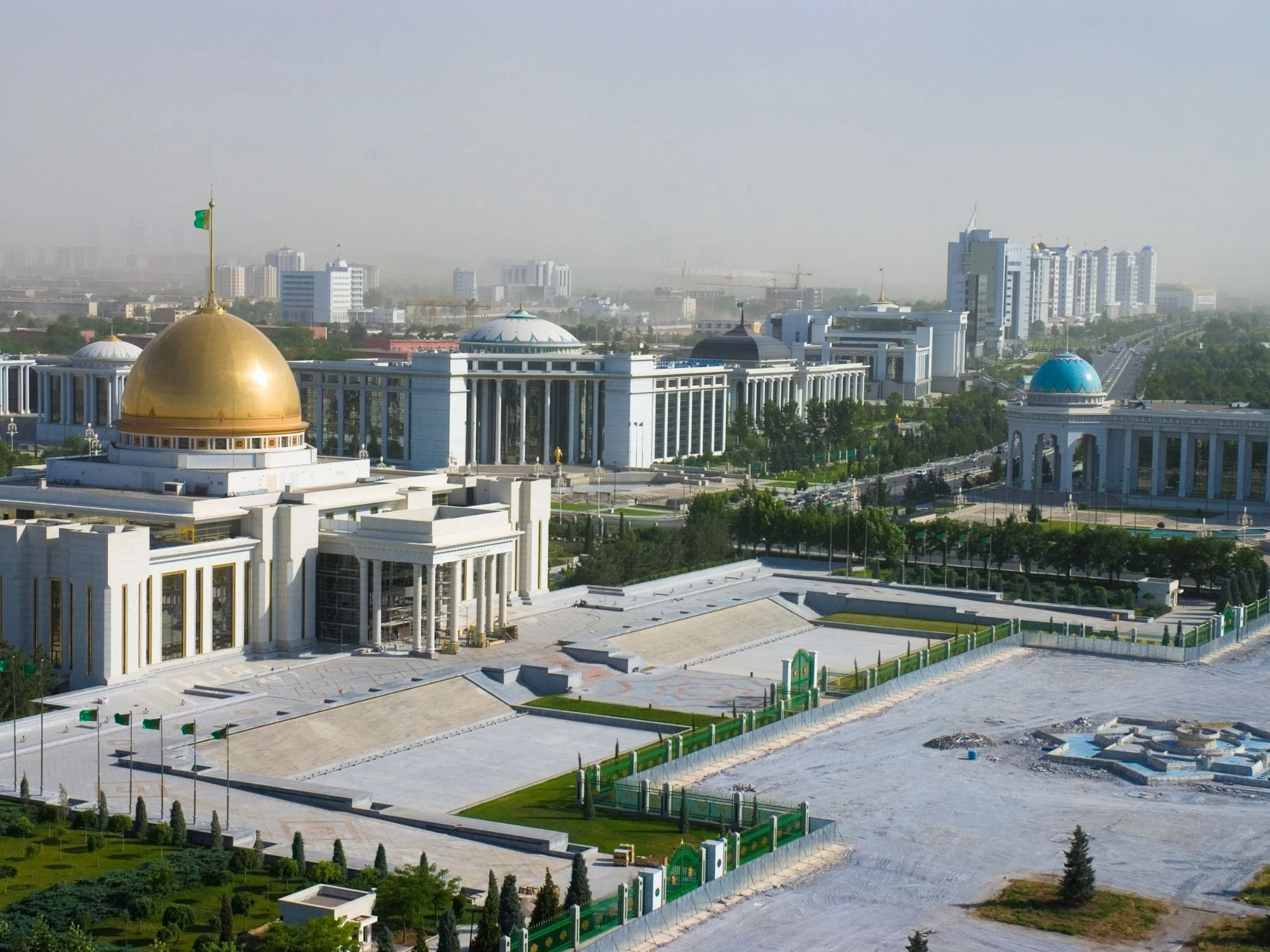 Golden-domed presidential palace among white marble government buildings in central Ashgabat
