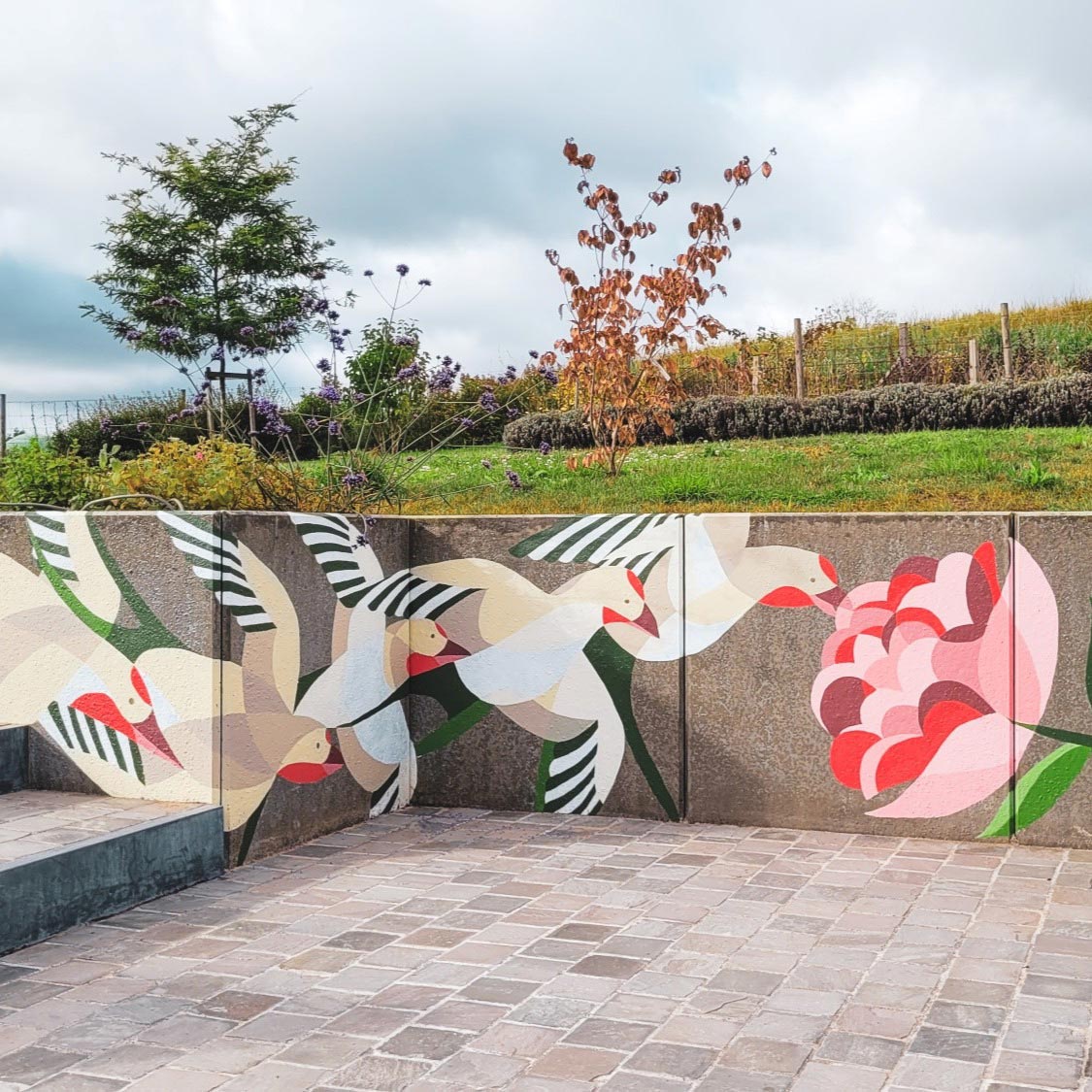 Fresque d'oiseaux et d'une main tenant une fleur rose