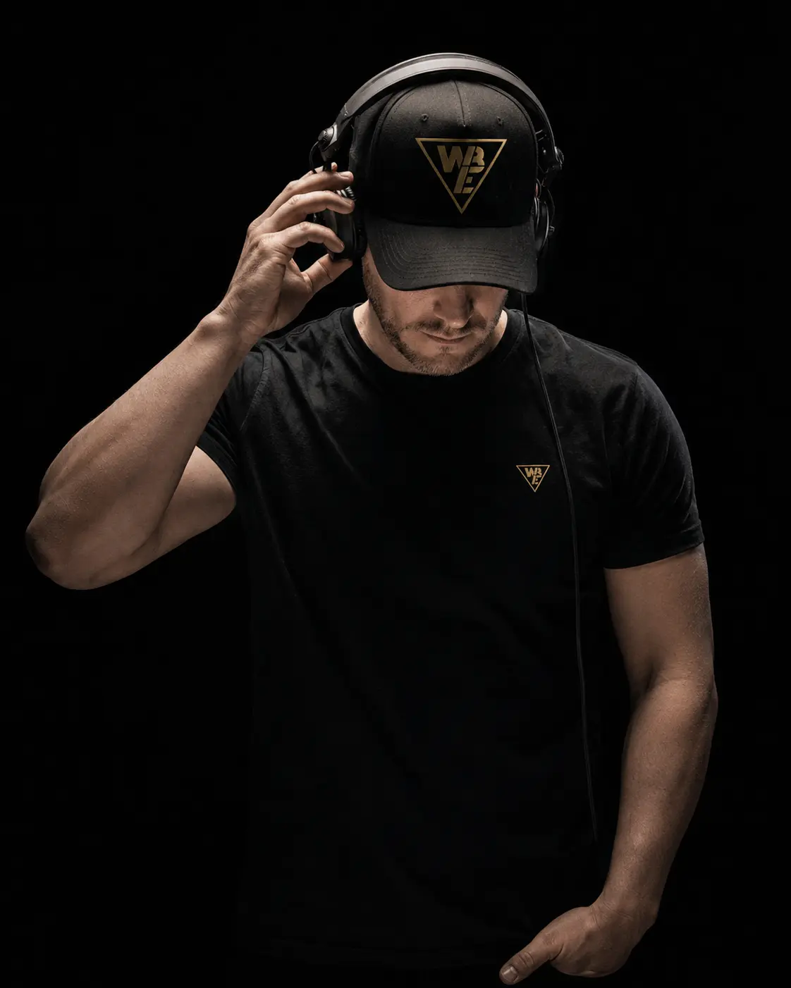 Professionelles DJ-Porträt für White & Black Events aus Winterbach mit Headset, Cap und goldenem Logo als Teil des Webdesigns von dencraft