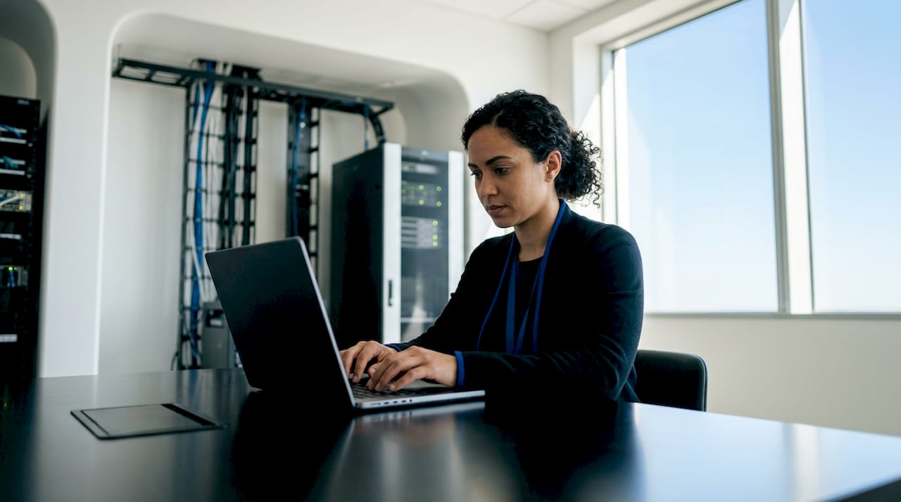 IT specialist working on carrier API integration laptop