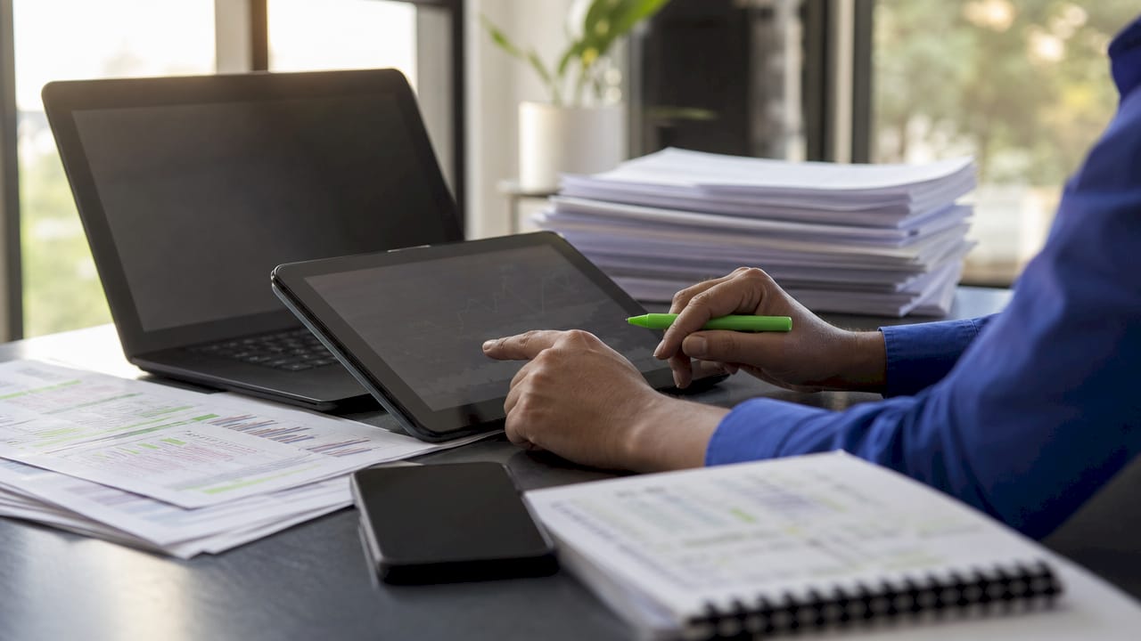 Close-up hands auditing freight invoices on tablet