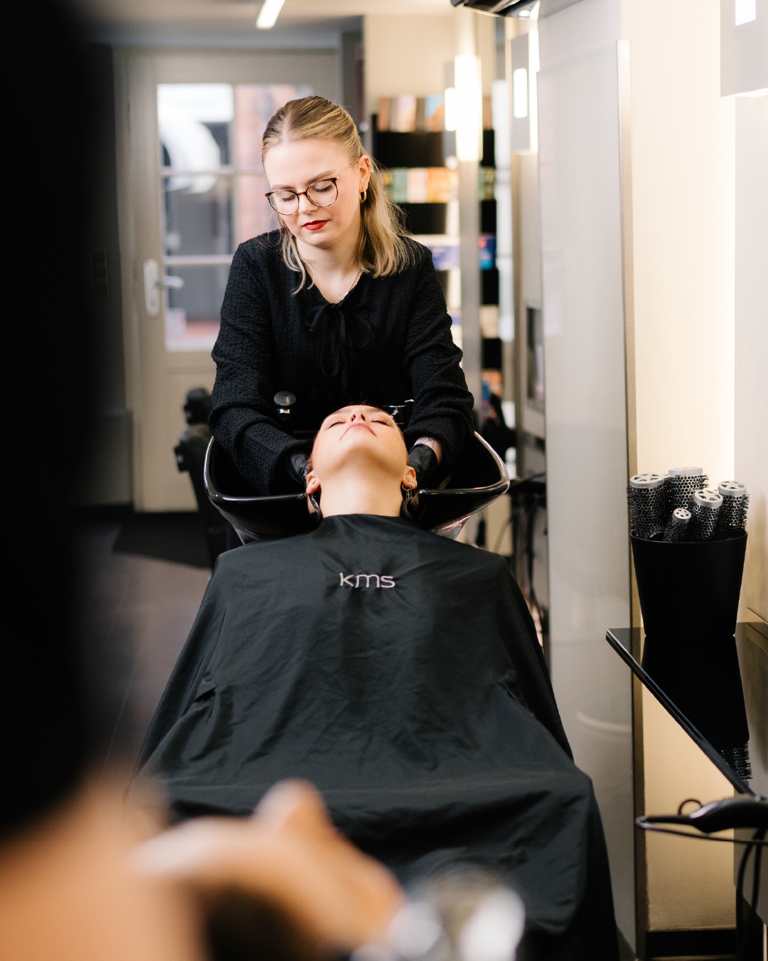 Friseurin wäscht einer Kundin die Haare am Waschbecken im Salon Hairdesign Kaiser in Lüneburg – Auftakt zu einem neuen Haarschnitt mit professioneller Haarpflege und Styling für frische Looks.