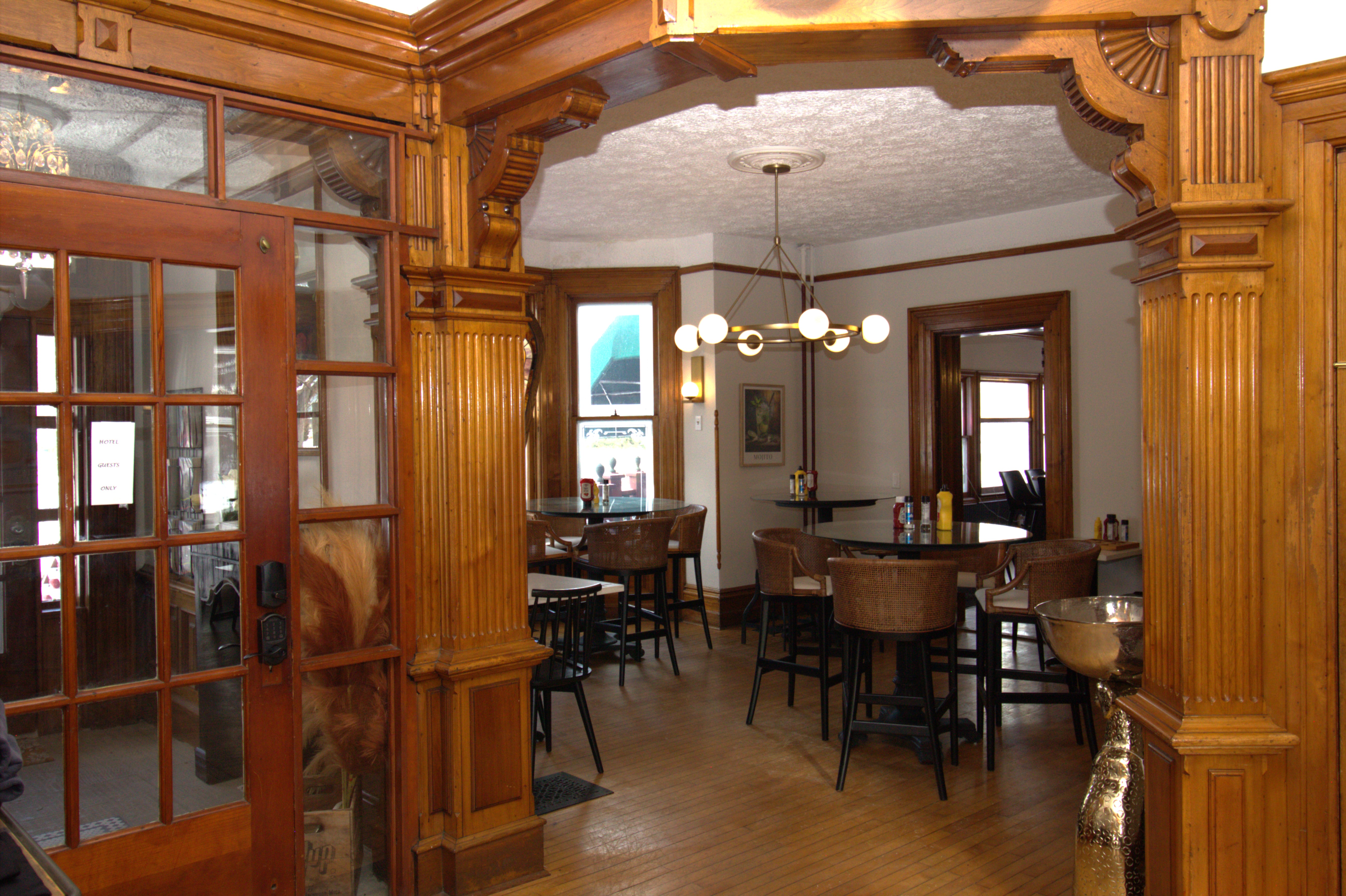 An historic entry with large wood moldings with tables and chairs arranged for guests 