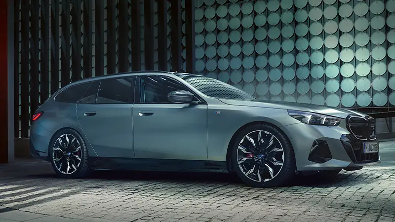 BMW i5 Touring M Sport in matter Lackierung vor moderner Architektur – BMW Wolter & Steiner in Neubrandenburg, Waren und Prenzlau