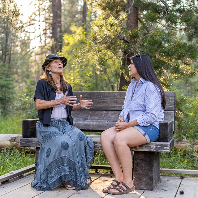 Barbi Buckles having a coaching session with a client on an outdoor bench