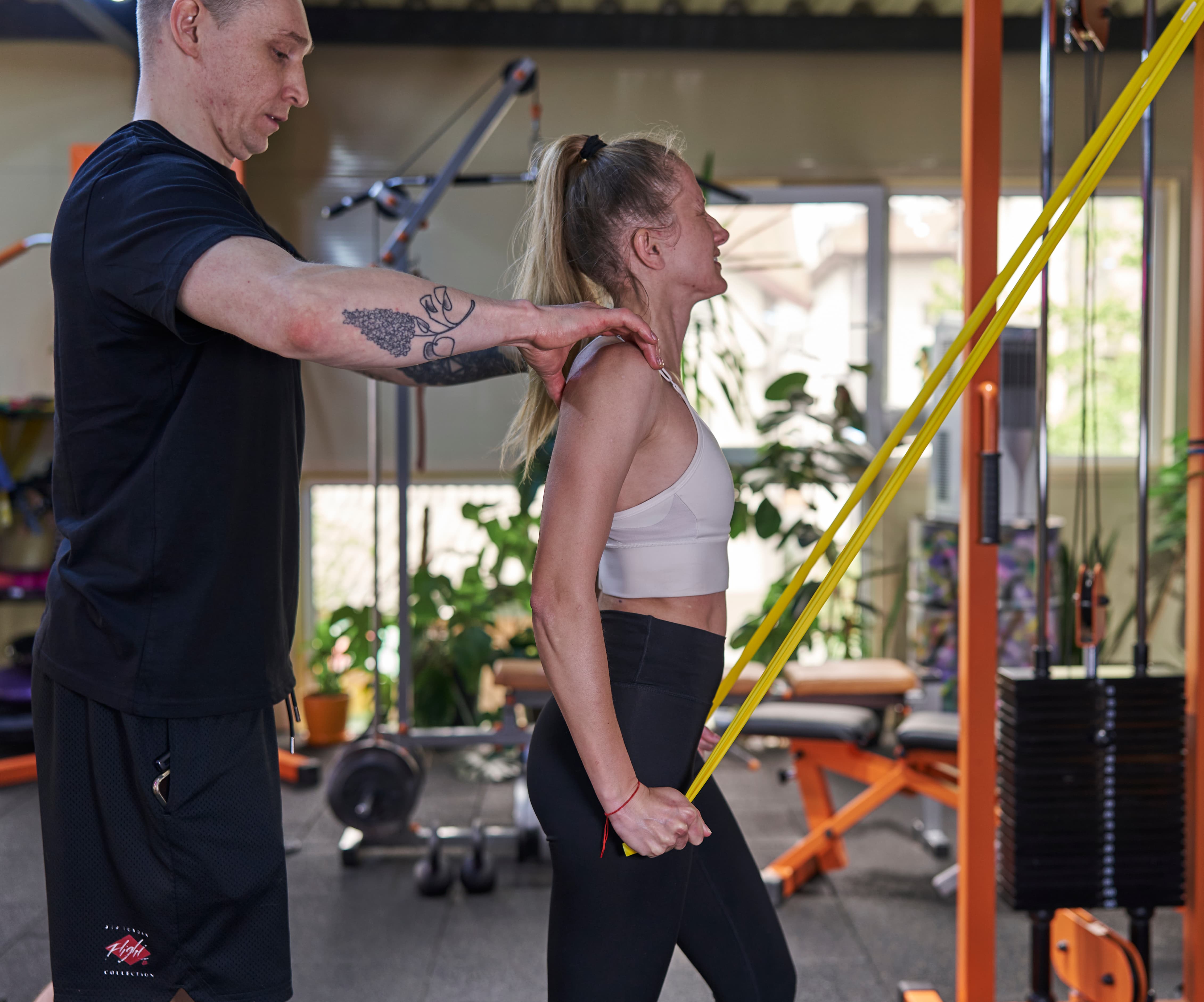 На фото представлена робота з плечовим поясом із використанням еластичного опору під контролем тренера. Основний акцент — відновлення правильної механіки руху плеча через стабілізацію та контроль положення лопатки.  У людей із сидячим способом життя часто формується порушення роботи лопатково-плечового комплексу: плечі зміщуються вперед, знижується контроль лопатки, а навантаження переходить на шийний відділ і поверхневі м’язи.  Після травм або хронічного перевантаження ключовим етапом є відновлення синхронної роботи лопатки та плечового суглоба. Це дозволяє зменшити біль, покращити рух і запобігти повторним ушкодженням.