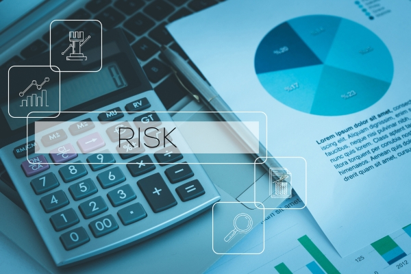 Calculator and pie chart representing financial risk and reward analysis
