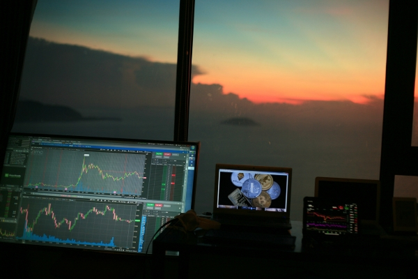 Trading desk with monitors showing financial charts, symbolizing hybrid investment strategy