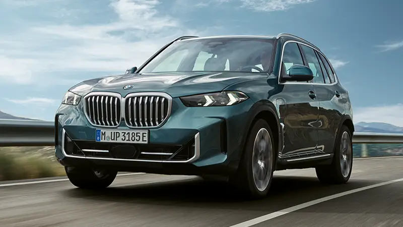 Grüner BMW X5 SUV fährt auf Landstraße bei blauem Himmel – BMW Baum Automobile in Bad Neuenahr-Ahrweiler