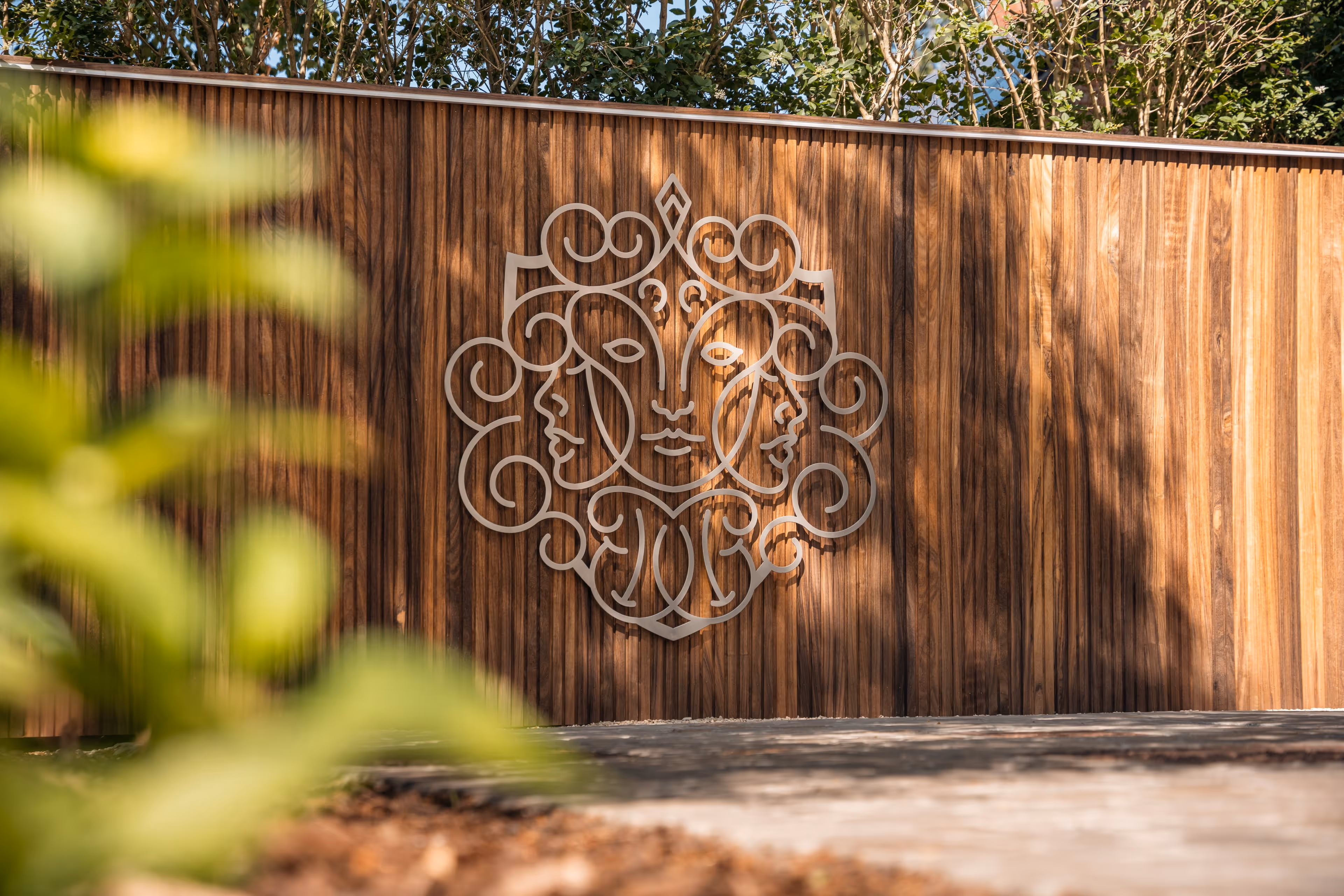 Houten poort met het sierlijk logo van Dr. Maarten Van Genechten.