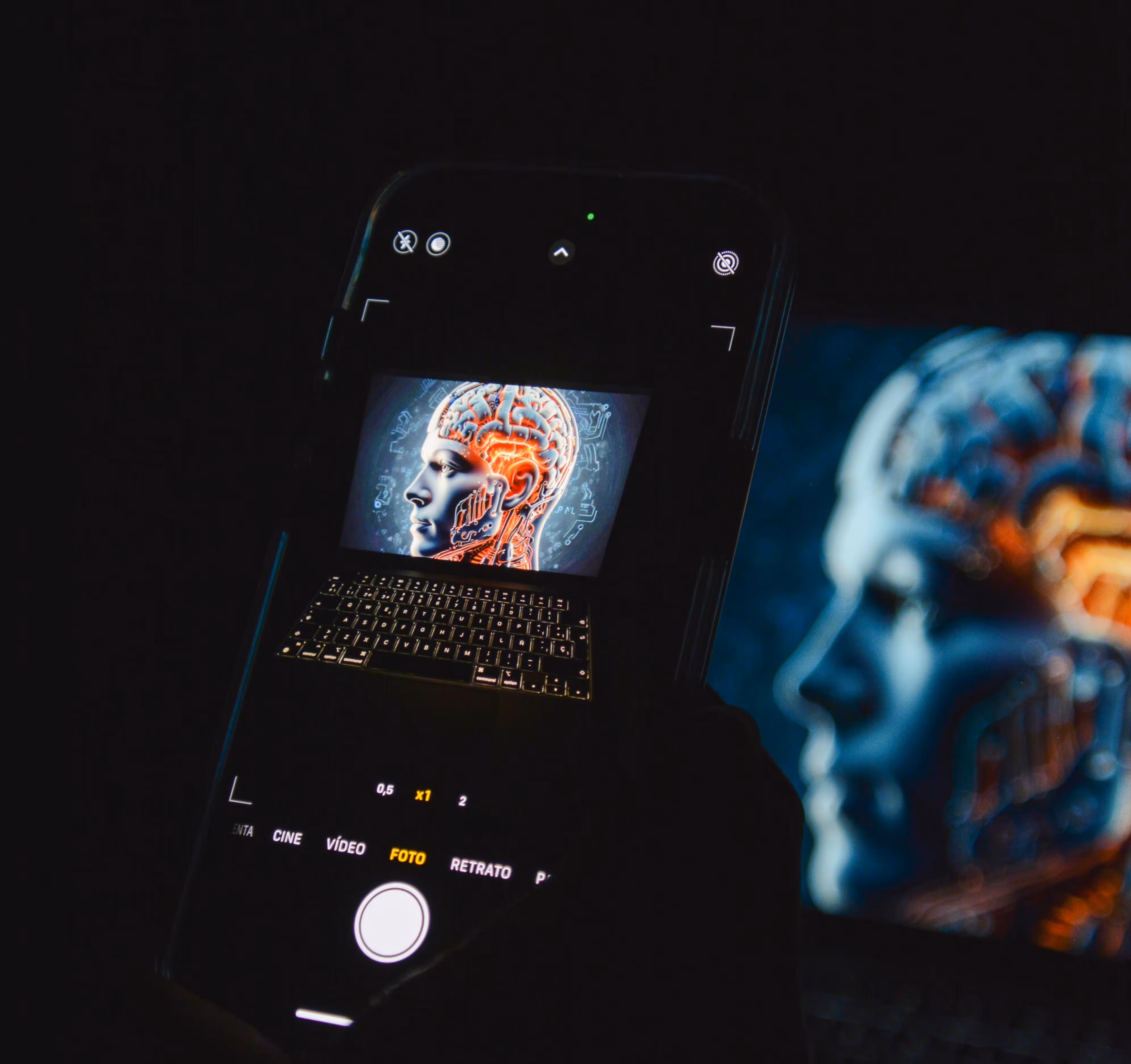A smartphone capturing an AI-generated image of a human head with illuminated brain circuits displayed on a laptop screen, representing artificial intelligence and digital innovation.