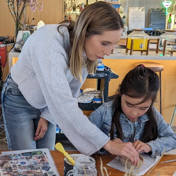 Fleur is working with a young child during a creative play activity