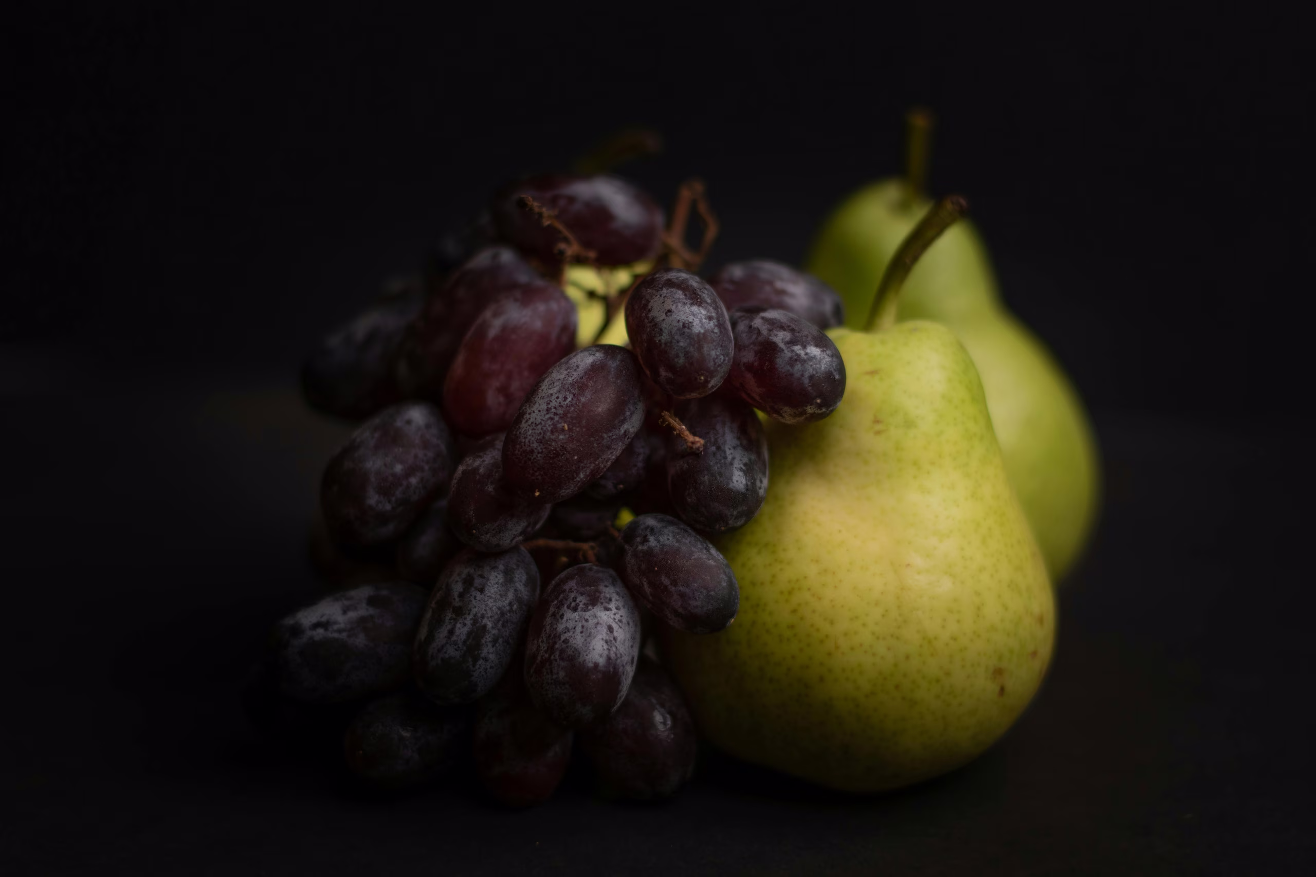 Grappe de raisins noirs et poires de saison pour l'offre culinaire éco-responsable et raffinée de l'hôtel 4 étoiles SNUUG.