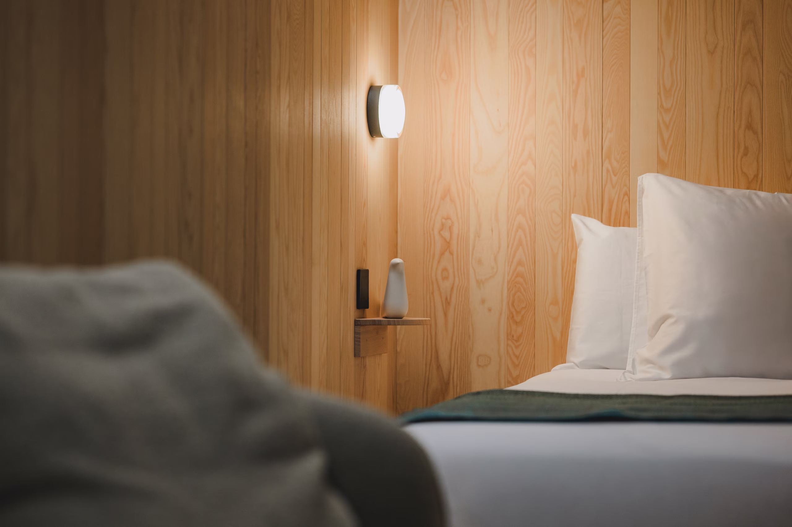 Camera minimalista in legno locale SNUUG, che offre tutto il comfort e la raffinatezza moderni di un hotel a 4 stelle eco-responsabile.