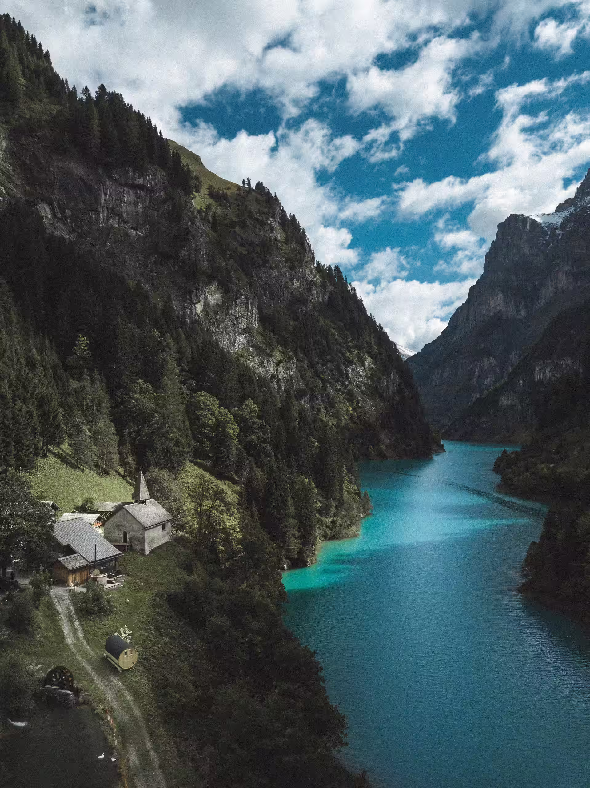 Soggiorno itinerante effimero SNUUG nel cuore delle Alpi svizzere, di fronte a un lago turchese e a una chiesa tradizionale, per un'immersione totale nella natura.