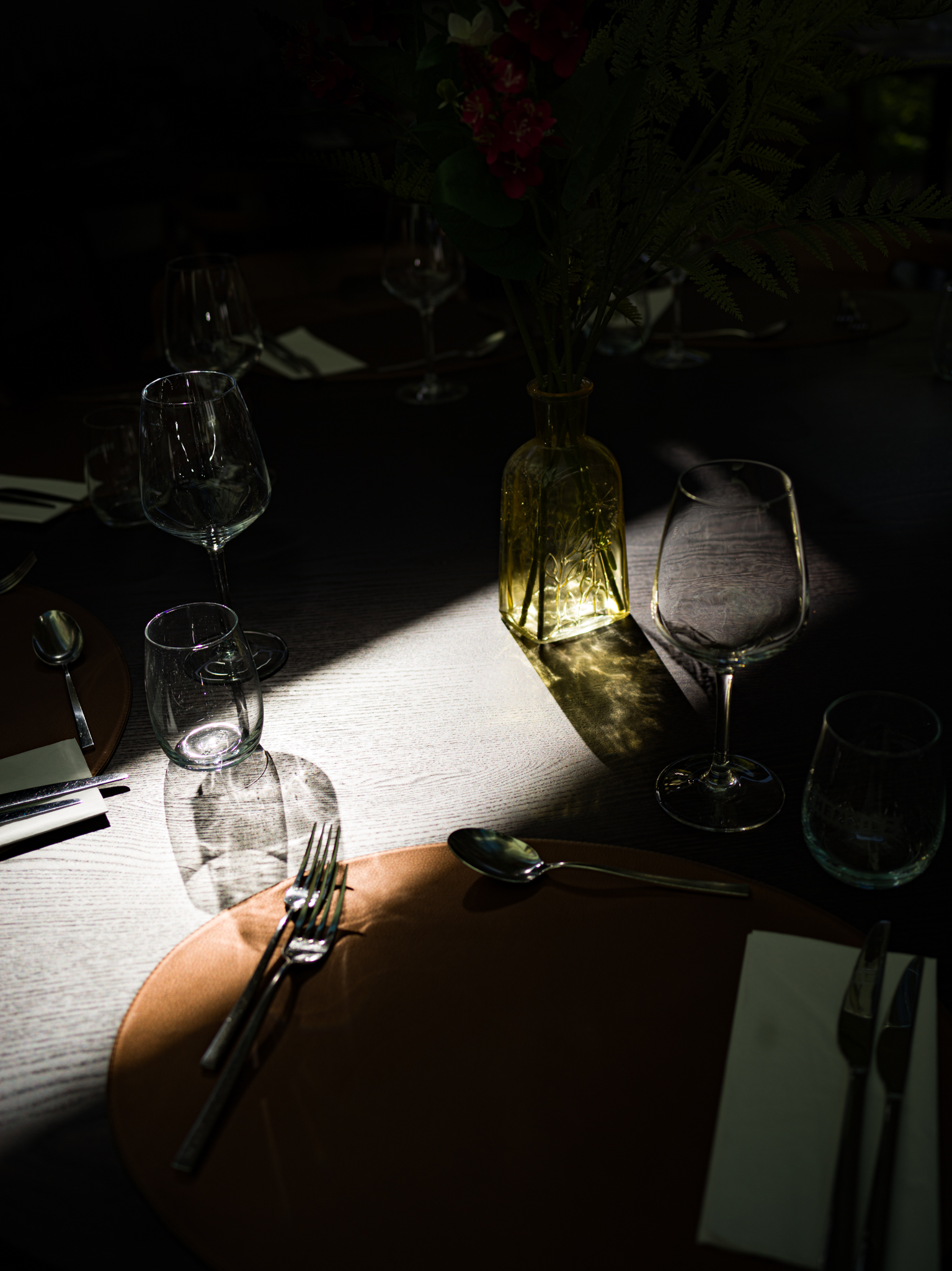 Table de dîner raffinée et tamisée dans un hébergement éco-responsable SNUUG en Suisse, illustrant la haute hôtellerie et la gastronomie de terroir.