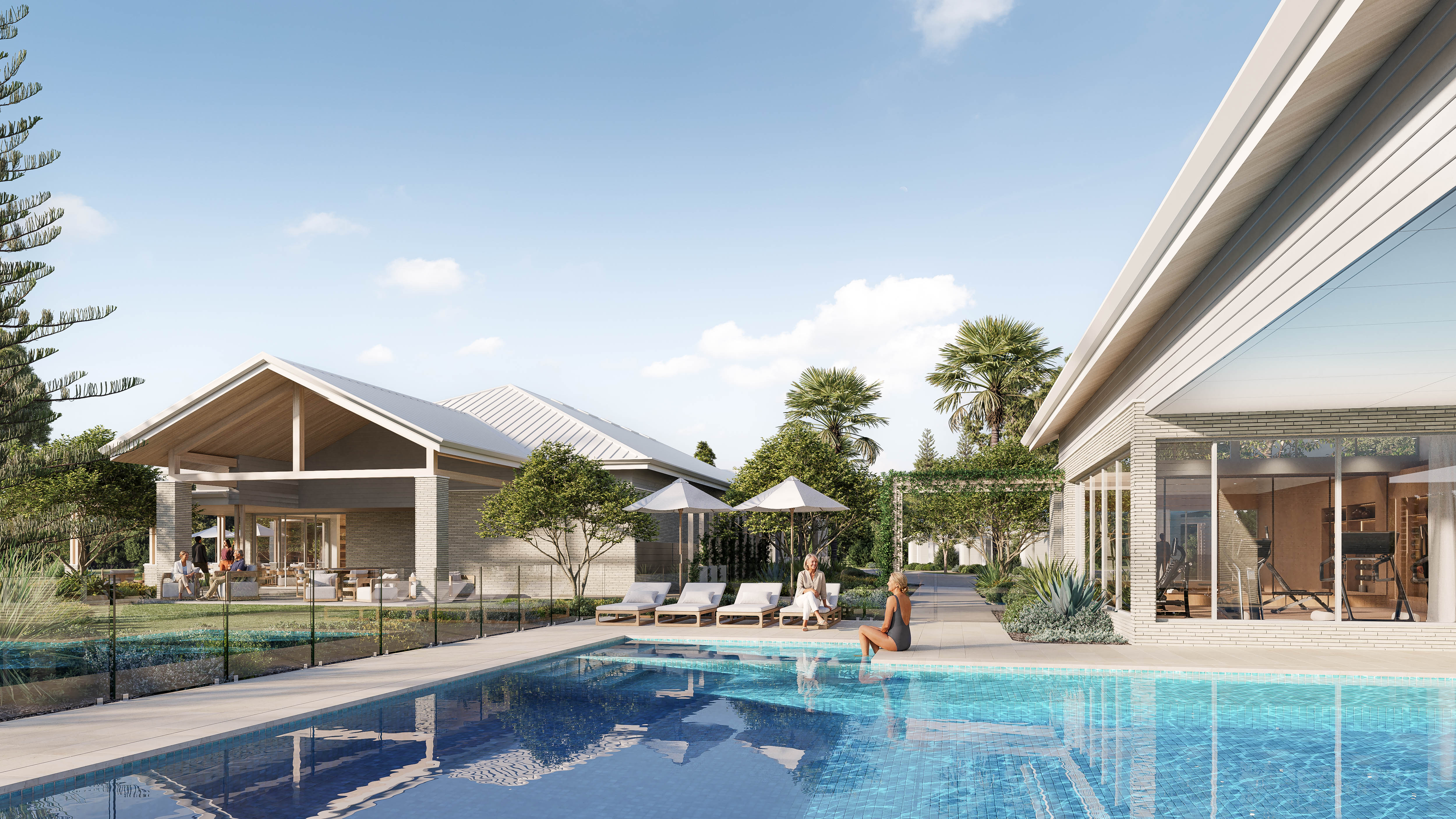 Modern wellness centre building with pitched roof, glass fenced pool, and surrounding landscaped greenery.