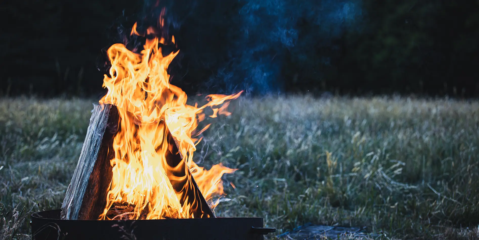 A crackling campfire in a Swiss landscape, SNUUG's concept of sustainable and exclusive nomadic stays.