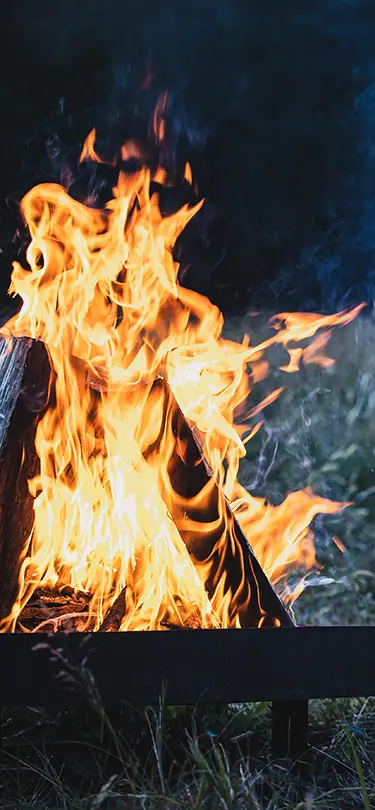 A crackling campfire in a Swiss landscape, SNUUG's concept of sustainable and exclusive nomadic stays.