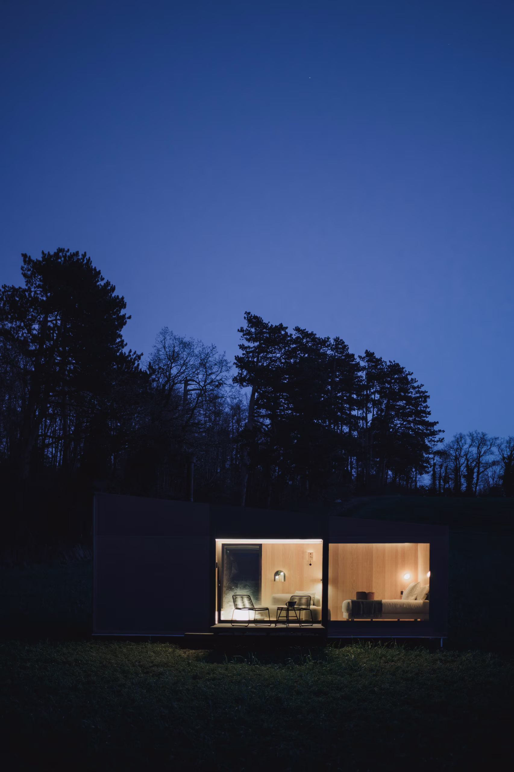 Designorientiertes und komfortables Interieur einer SNUUG-Hütte bei Nacht, ein Konzept für gehobene Nomaden-Hotellerie in der Schweiz.